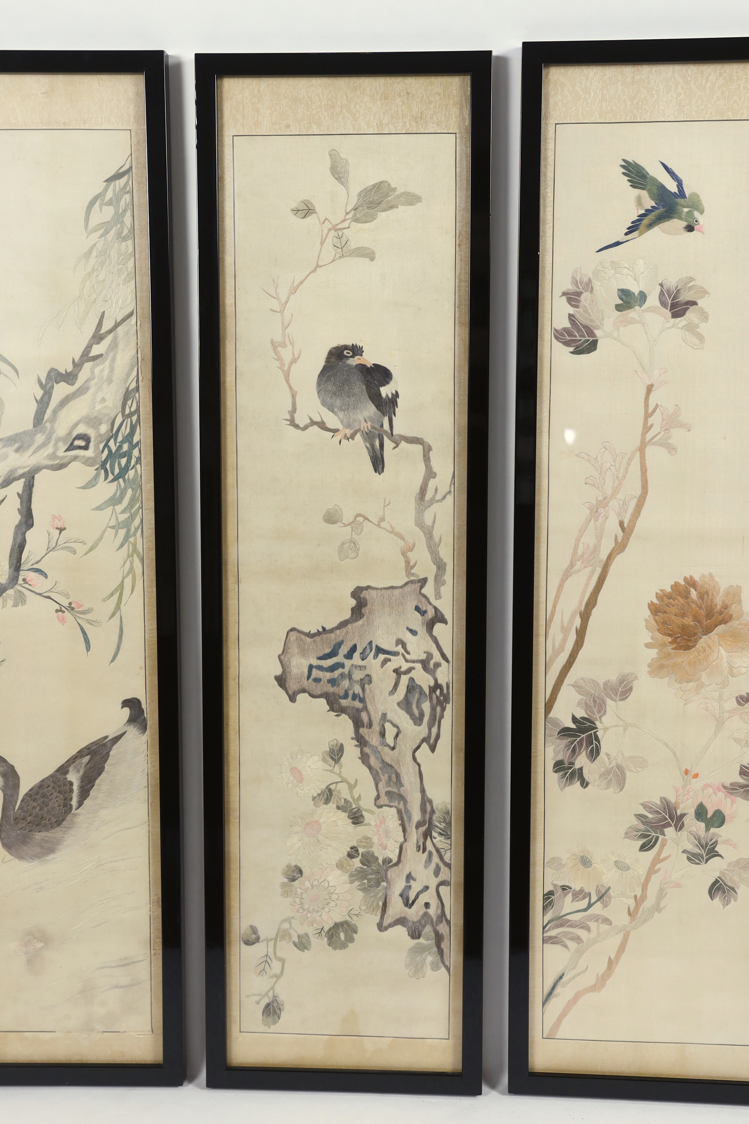 A set of four framed Chinese silk embroideries, of “The Four Seasons”, late Qing dynasty, embroidered with birds and trees and flowers, 96cm high x 22cm wide